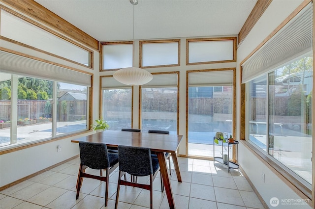 sunroom with tile patterned flooring and baseboards