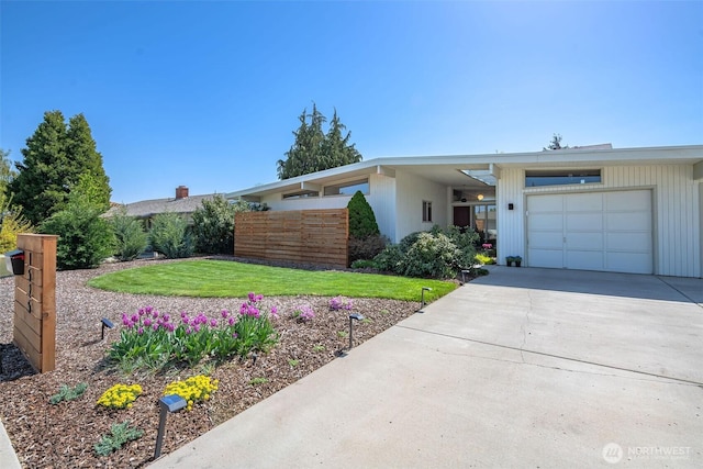 view of front of house with an attached garage, driveway, and a front yard