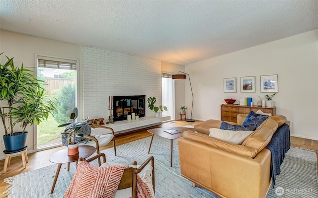 living area featuring wood finished floors, a fireplace, and a textured ceiling