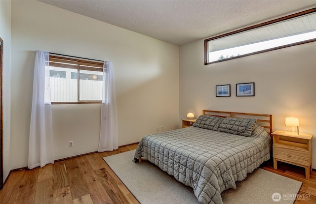 bedroom featuring wood finished floors and a textured ceiling