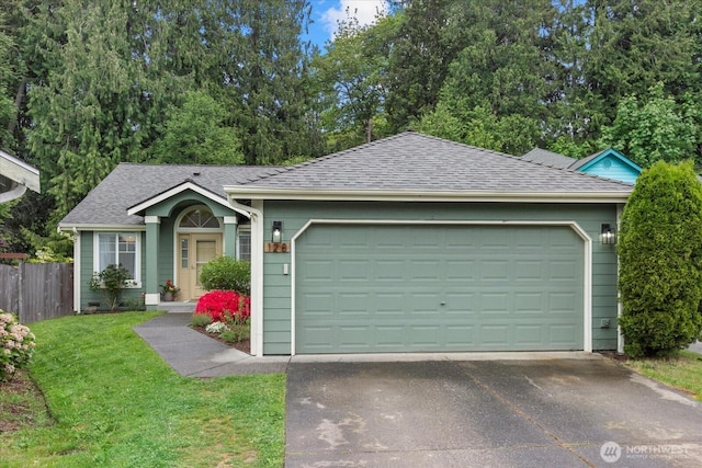 ranch-style home with a shingled roof, an attached garage, and driveway