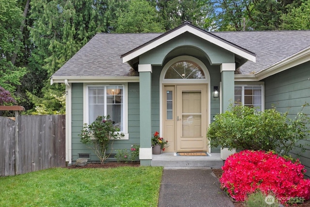 view of exterior entry with a shingled roof