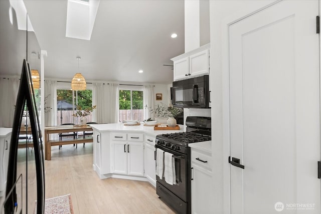 kitchen with black appliances, a peninsula, light countertops, recessed lighting, and white cabinets