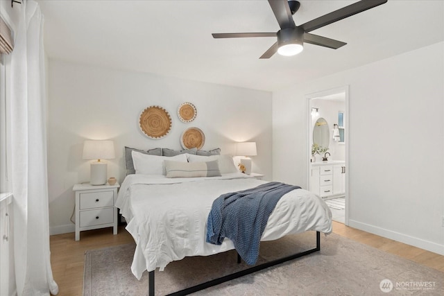 bedroom with wood finished floors, baseboards, ensuite bath, and a ceiling fan