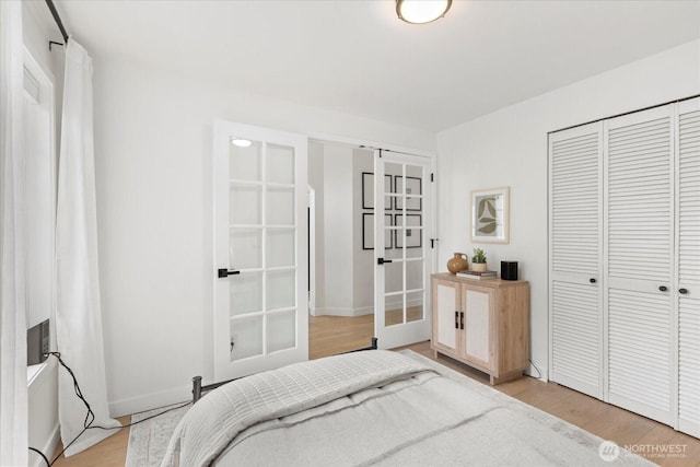 bedroom with french doors, light wood-type flooring, a closet, and baseboards