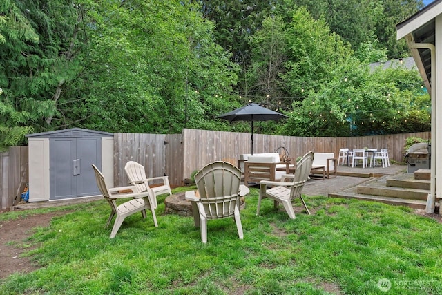 view of yard featuring a fire pit, a storage unit, an outdoor structure, and a patio area