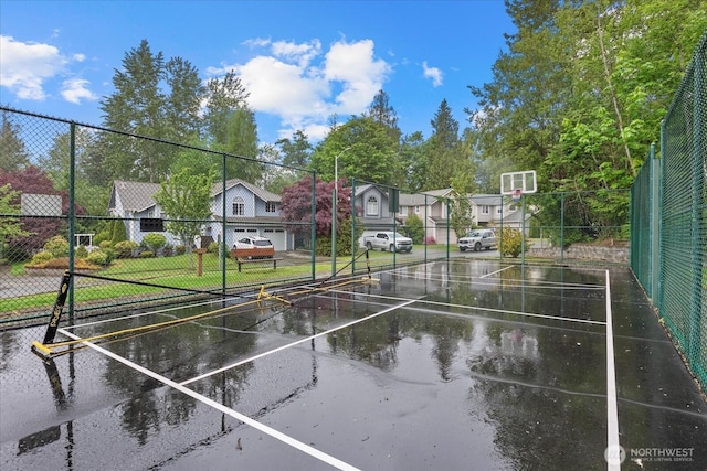 view of basketball court with fence and a residential view