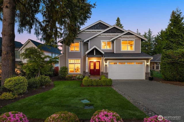 craftsman-style house featuring a garage, driveway, stone siding, and a front lawn