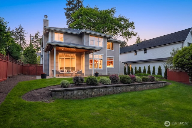 back of house featuring a chimney, outdoor lounge area, and a patio