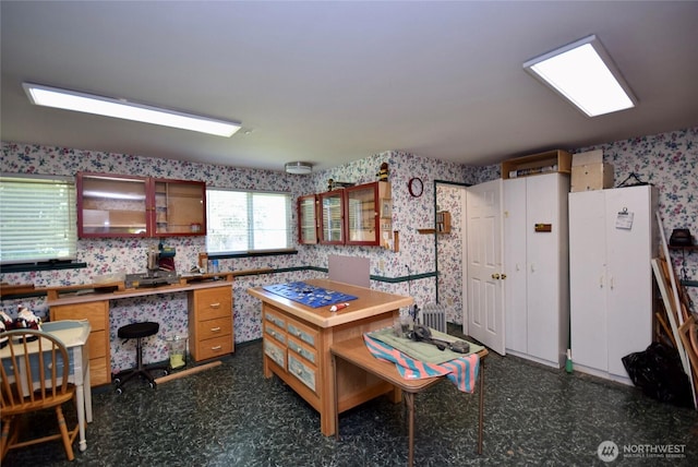 171 Foxtail Ln, Sequim, WA 98382 - kitchen with wallpapered walls, dark flooring, an office area, and glass insert cabinets