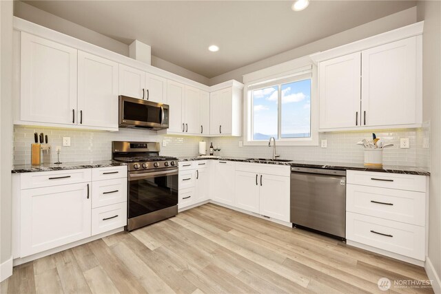 470 S Partridge Ln, East Wenatchee, WA 98802 - kitchen featuring stainless steel appliances, a sink, dark stone counters, backsplash, and white cabinetry