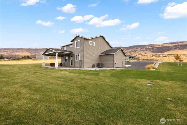 470 S Partridge Ln, East Wenatchee, WA 98802 - back of house with a patio area, central AC, a mountain view, and a lawn