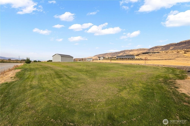 470 S Partridge Ln, East Wenatchee, WA 98802 - view of grassy yard featuring a rural view, a mountain view, and an outbuilding