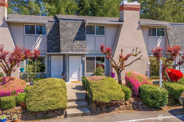 8309 Cirque Dr W Unit 4, University Place, WA 98467 - view of front facade featuring a chimney, a shingled roof, and stucco siding