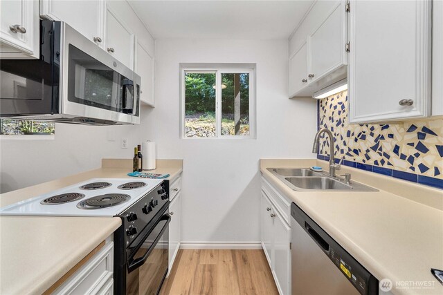 8309 Cirque Dr W Unit 4, University Place, WA 98467 - kitchen featuring stainless steel appliances, a sink, light wood-type flooring, backsplash, and white cabinetry