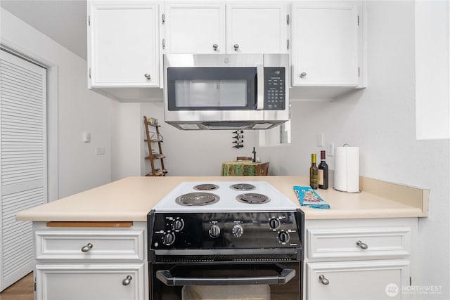 8309 Cirque Dr W Unit 4, University Place, WA 98467 - kitchen with stainless steel microwave, black electric range, light countertops, and white cabinets