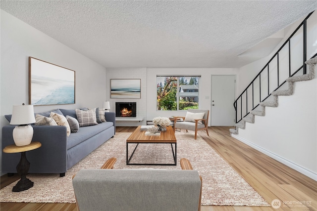 8309 Cirque Dr W Unit 4, University Place, WA 98467 - living area with wood finished floors, stairway, a textured ceiling, a fireplace, and baseboards