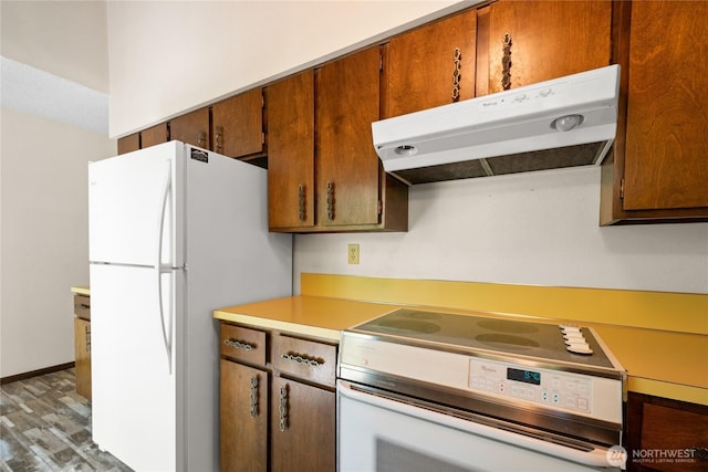 2431 W Lynnwood Dr, Longview, WA 98632 - kitchen featuring range with electric cooktop, under cabinet range hood, freestanding refrigerator, wood finished floors, and light countertops