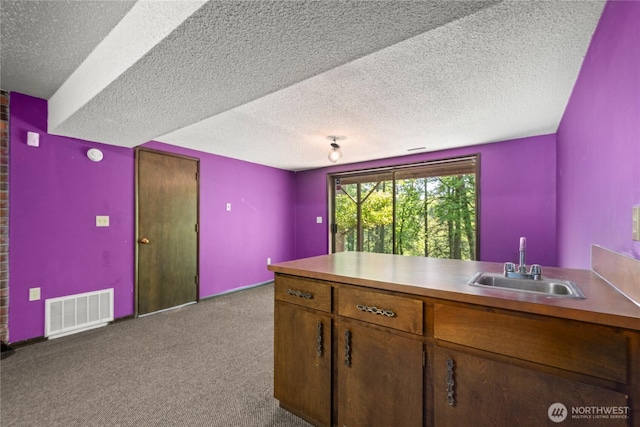 2431 W Lynnwood Dr, Longview, WA 98632 - kitchen with a sink, carpet, a textured ceiling, a peninsula, and brown cabinetry
