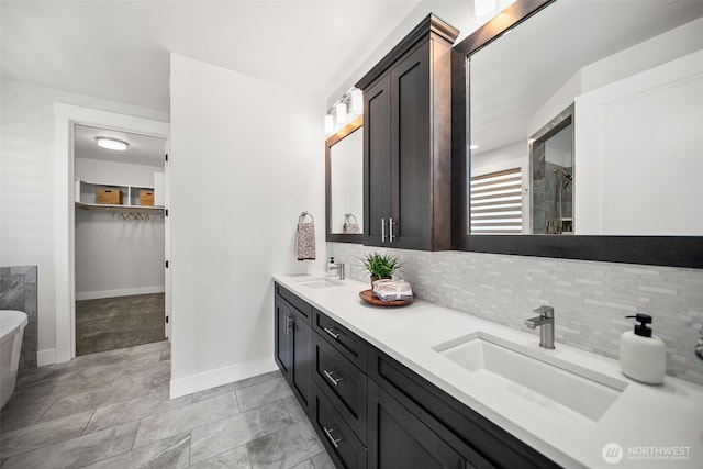 2876 N Brysen Dr, East Wenatchee, WA 98802 - bathroom featuring backsplash, baseboards, a walk in closet, double vanity, and tiled shower