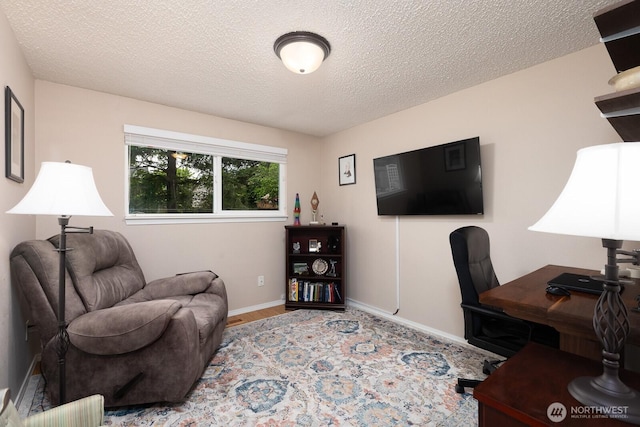 office with baseboards, a textured ceiling, and wood finished floors