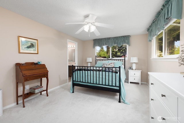 bedroom featuring light carpet, baseboards, and ensuite bathroom