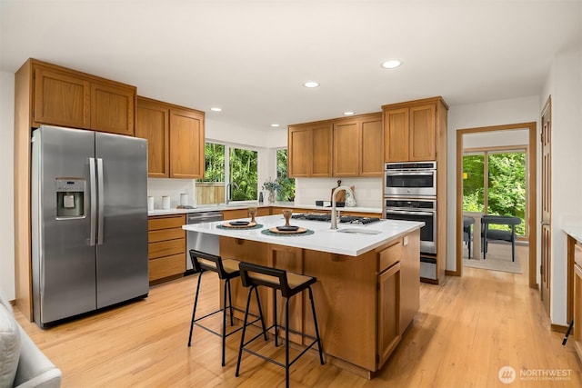 5047 84th Ave SE, Mercer Island, WA 98040 - kitchen featuring stainless steel appliances, brown cabinets, light wood-type flooring, light countertops, and recessed lighting