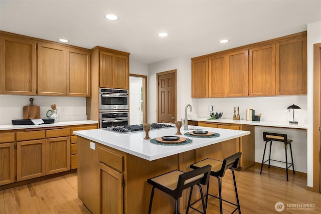 5047 84th Ave SE, Mercer Island, WA 98040 - kitchen featuring stainless steel appliances, light countertops, a kitchen island with sink, a kitchen bar, and recessed lighting