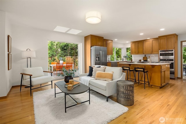 5047 84th Ave SE, Mercer Island, WA 98040 - living area with light wood-type flooring, plenty of natural light, a skylight, recessed lighting, and baseboards