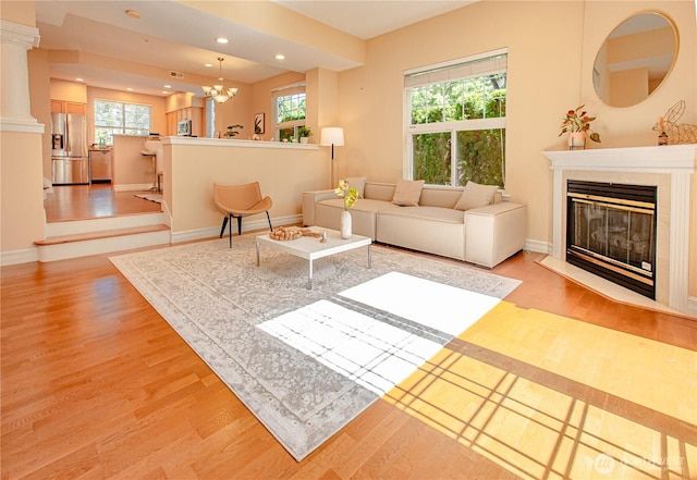 2050 132nd Ave SE Unit E-512, Bellevue, WA 98005 - living area featuring light wood finished floors, a fireplace with flush hearth, recessed lighting, baseboards, and a chandelier
