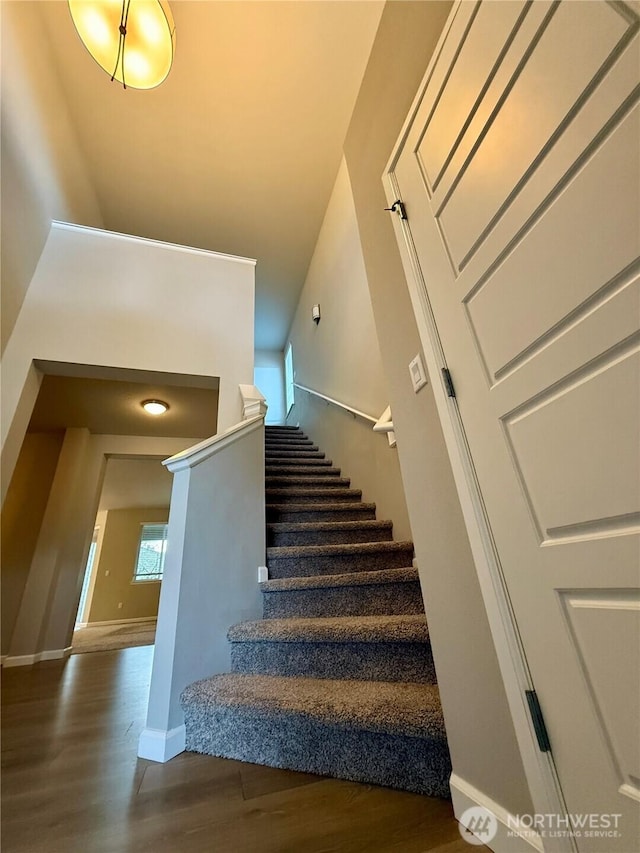 18002 38th Avenue Ct E, Tacoma, WA 98446 - stairway featuring wood finished floors, baseboards, and a towering ceiling