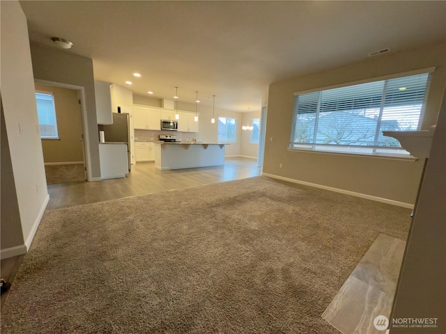 18002 38th Avenue Ct E, Tacoma, WA 98446 - unfurnished living room featuring light colored carpet, baseboards, and recessed lighting