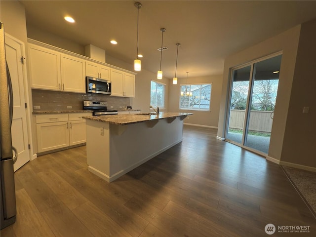 18002 38th Avenue Ct E, Tacoma, WA 98446 - kitchen featuring stainless steel appliances, white cabinetry, light stone counters, tasteful backsplash, and recessed lighting