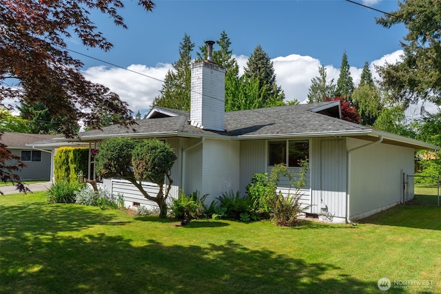 rear view of property featuring a chimney and a shingled roof