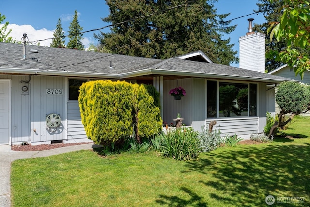 single story home featuring a front lawn, a chimney, and a shingled roof