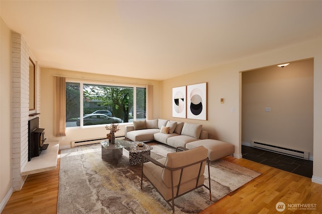 living area with a baseboard heating unit, light wood-type flooring, baseboards, and a fireplace