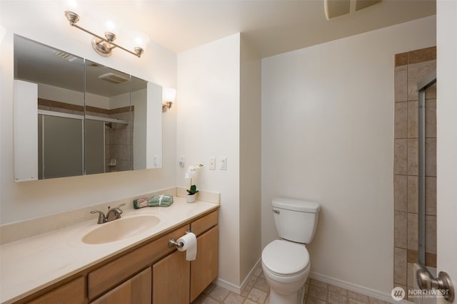 bathroom with tiled shower, toilet, vanity, and baseboards