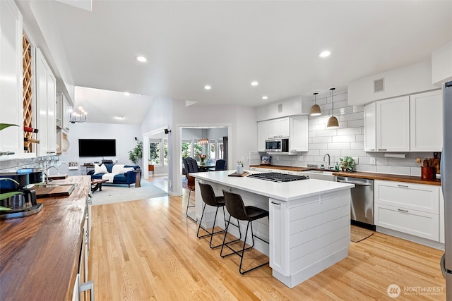 7340 Hawkstone Ave SW, Port Orchard, WA 98367 - kitchen with butcher block counters, appliances with stainless steel finishes, open floor plan, a breakfast bar area, and recessed lighting