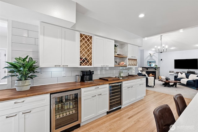 7340 Hawkstone Ave SW, Port Orchard, WA 98367 - indoor bar with beverage cooler, tasteful backsplash, recessed lighting, light wood-type flooring, and a glass covered fireplace