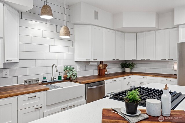 7340 Hawkstone Ave SW, Port Orchard, WA 98367 - kitchen featuring butcher block countertops, a sink, stainless steel dishwasher, backsplash, and white cabinetry
