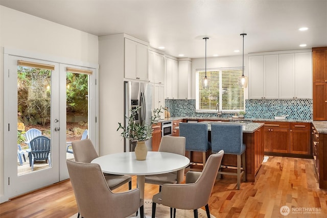 kitchen featuring french doors, tasteful backsplash, light wood-style flooring, healthy amount of natural light, and recessed lighting