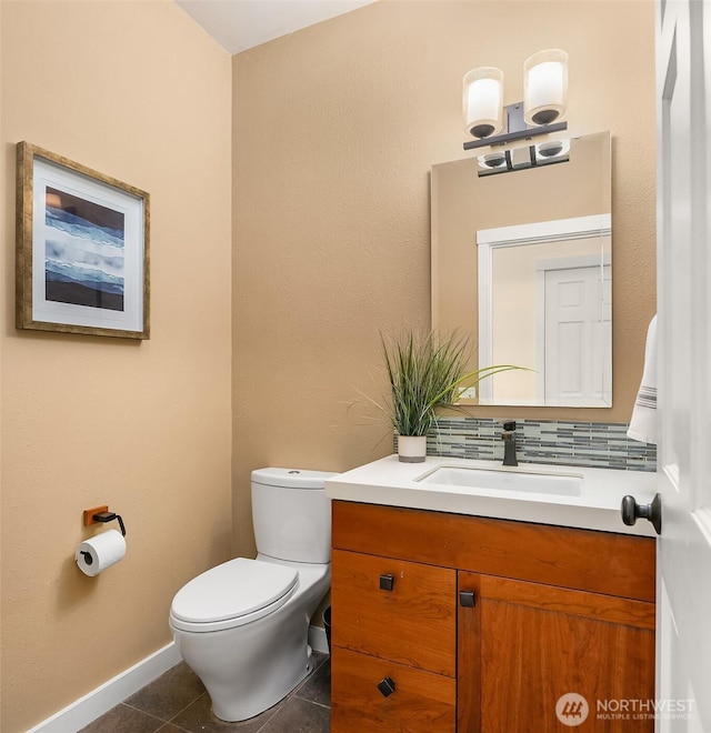 bathroom featuring toilet, tile patterned floors, vanity, and baseboards