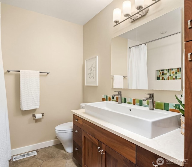 full bathroom featuring baseboards, toilet, and vanity