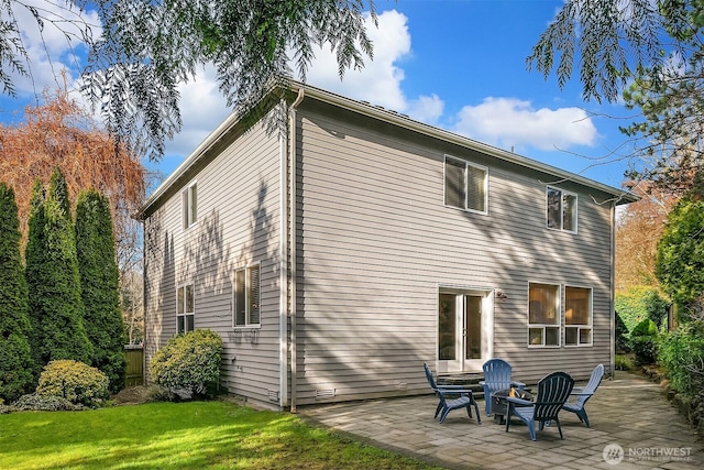 rear view of house with a patio and a lawn