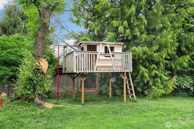view of jungle gym with a wooden deck and a lawn
