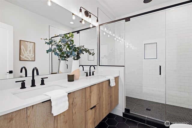 bathroom featuring a shower stall, tile patterned flooring, and double vanity