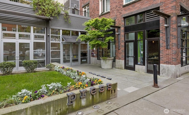 view of exterior entry with french doors and brick siding