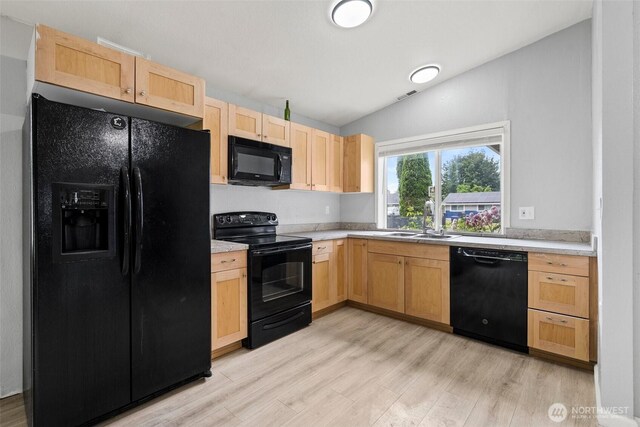 7225 E F St, Tacoma, WA 98404 - kitchen with black appliances, light brown cabinetry, light countertops, light wood-style flooring, and vaulted ceiling