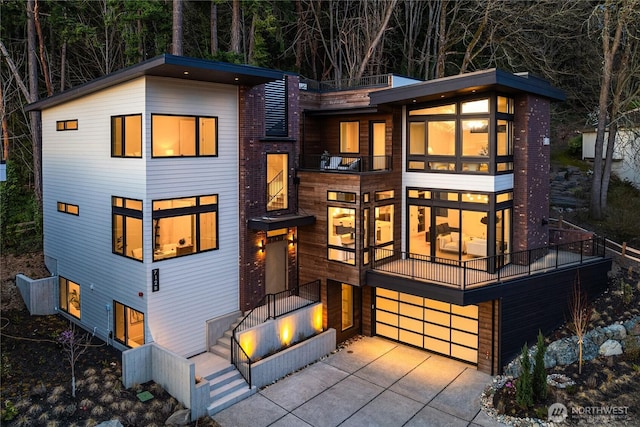 7128 NE 119th Ln, Kirkland, WA 98034 - contemporary home featuring an attached garage, concrete driveway, and a balcony