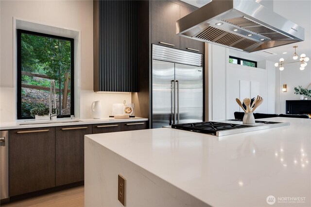 7128 NE 119th Ln, Kirkland, WA 98034 - kitchen featuring exhaust hood, appliances with stainless steel finishes, light countertops, dark brown cabinetry, and modern cabinets